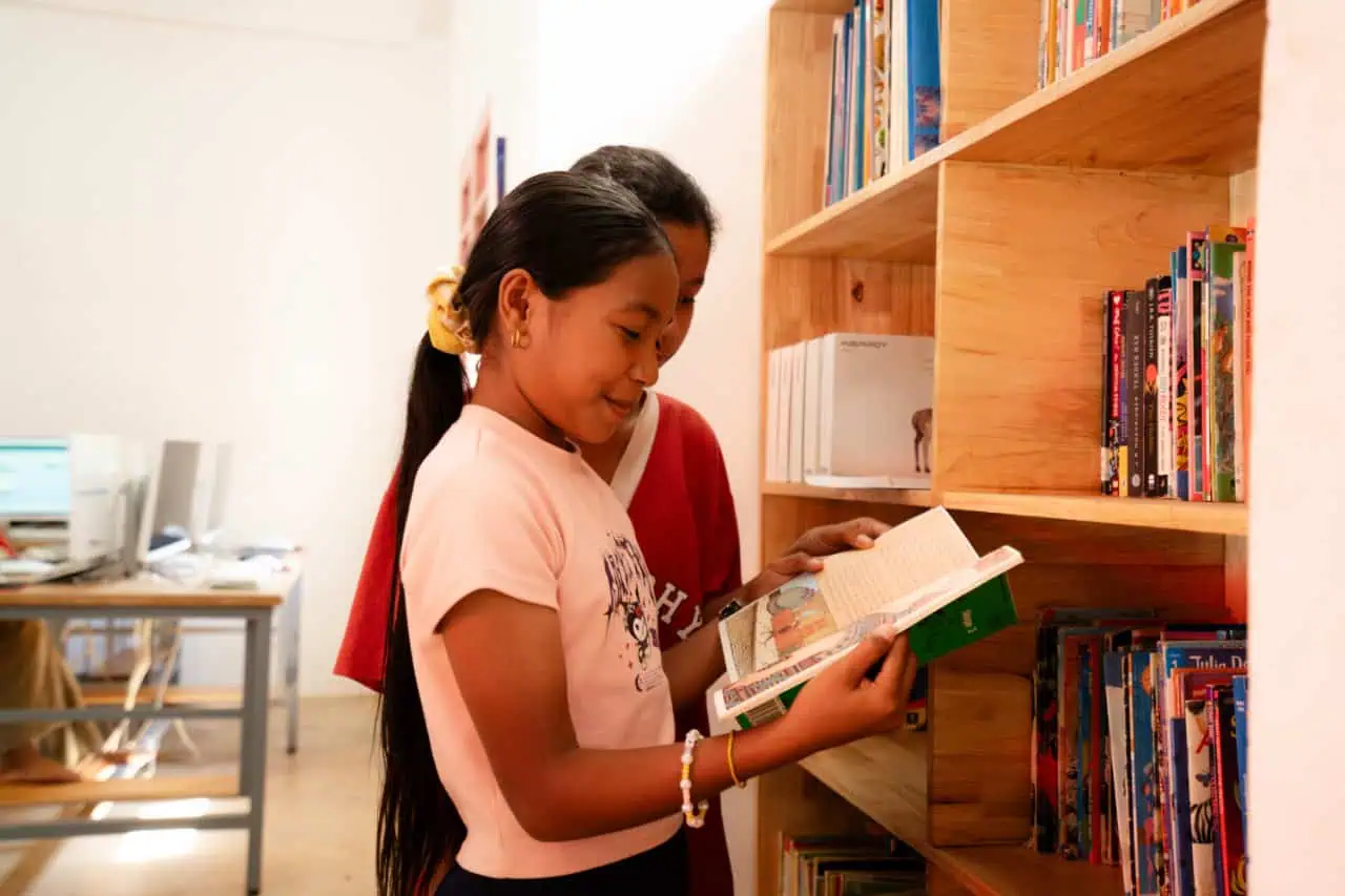 Students Reading a Book in a Library