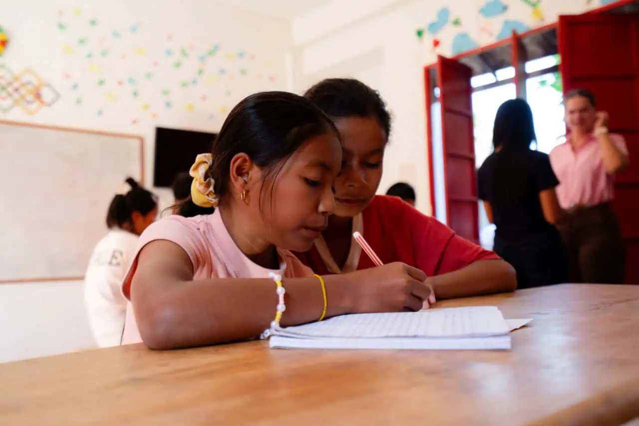 Students Writing in a Notebook at a Classroom
